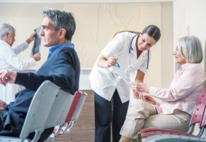 Doctors and patients speaking in the hospital waiting room.
